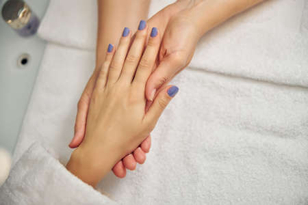 Beautician holding woman hand after doing manicureの写真素材