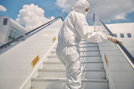 Airport worker in a protective suit standing outdoorsの写真素材