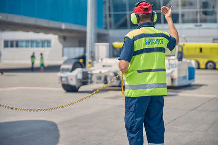 Supervisor standing in front of a pushback tug