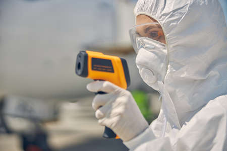 Health official in a protective suit standing outside