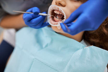 Kid with a dental latex dam in his mouthの写真素材