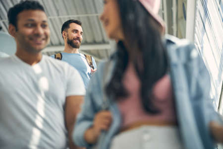 Bearded man standing behind male with woman in the indoors
