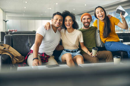 Young people hanging fun together in airport while waiting their flight
