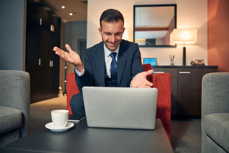 Happy man having online meeting in the hotel room
