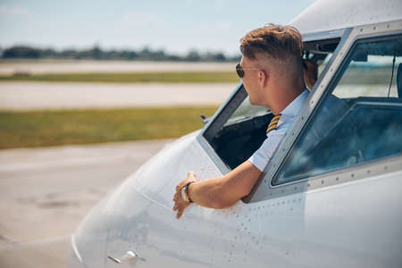 Handsome airline pilot sitting inside airplane cockpitの写真素材
