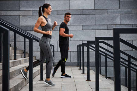 Merry woman running with boyfriend in cityの写真素材