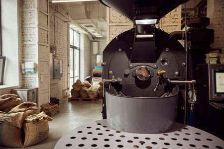 Coffee roasting machine and coffee beans in bagsの写真素材