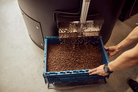 Young man using professional coffee roasting machineの写真素材