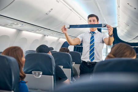 Handsome steward training safety prior procedures to flight take offの写真素材