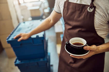 Male worker hand holding black cup of coffeeの写真素材