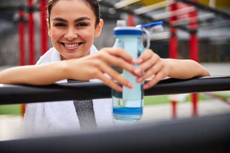 Happy pretty woman training on sports ground outdoorsの写真素材