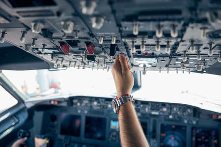 Pilot hand pushing on the dashboard in the aircraftの写真素材