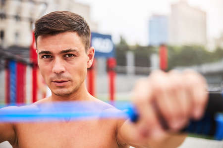 Handsome young man with skipping rope outdoors