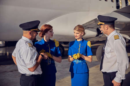 Happy friendly flight team talking together in the outdoors