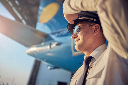 Handsome man in sunglasses holding hand near headの写真素材