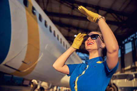Happy smiling woman in business uniform enjoying good weather while spending time in the aerodromeの写真素材