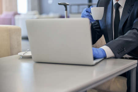 Businessman working on laptop in airport lounge