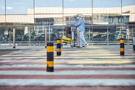 Two elderly people passing by the airport terminal buildingの写真素材