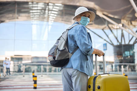 Elderly lady in a face mask standing outsideの写真素材