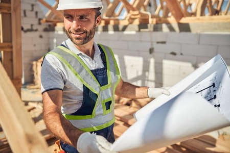 Cheerful young architect working at big project