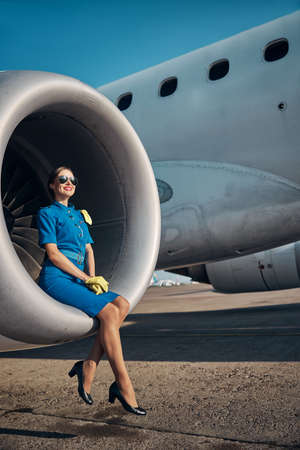 Happy young stewardes relaxing on jet turbineの写真素材