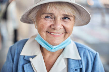 Smiling aged woman in a hat posing for the cameraの写真素材
