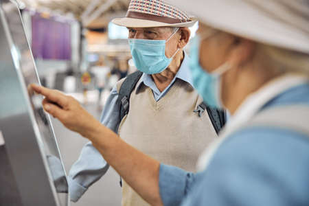 Elderly tourist couple checking in their baggageの写真素材
