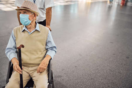 Disabled person in a transport chair staring awayの写真素材