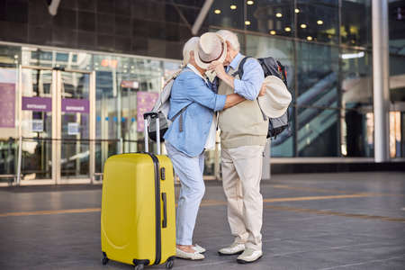 Senior couple hiding their faces behind a hatの写真素材