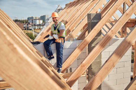 Smiley builder in a hard hat holding a drill driverの写真素材