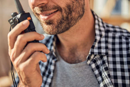 Smiley brunette man communicating on the wireless radioの写真素材