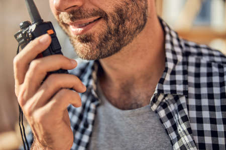 Smiley brunette man communicating on the wireless radio