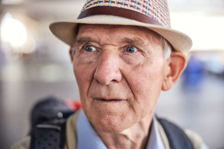 Sad elderly traveler gazing into the distanceの写真素材
