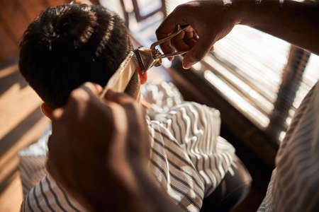 Barber cutting client hair with vintage hair trimmerの写真素材