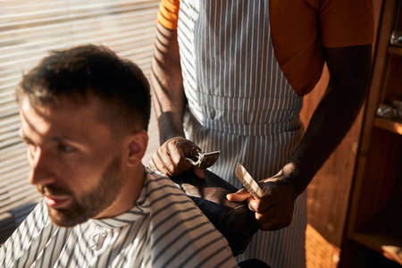 Handsome bearded gentleman getting haircut in barbershopの写真素材