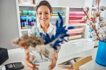 Smiley brunette woman working at a flower shop