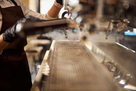 Barista holding pitcher making milk stream for coffeeの写真素材