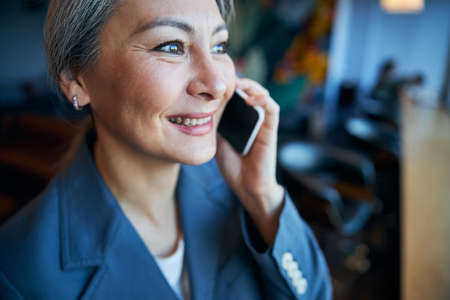 Beautiful cheerful woman talking on mobile phoneの写真素材