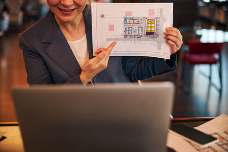 Businesswoman discussing architectural plan with colleague online