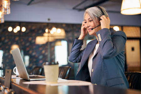 Charming businesswoman using laptop for online communication