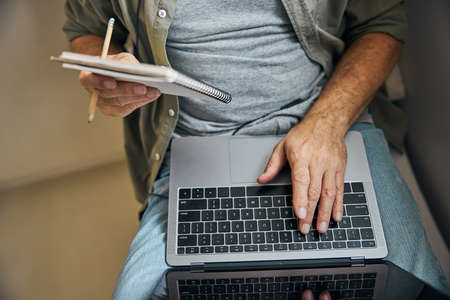 Working gentleman with a laptop and a personal notepad