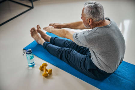 Fit senior citizen stretching towards his toes while exercisingの写真素材