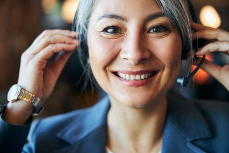 Beautiful cheerful woman wearing headset with microphoneの写真素材
