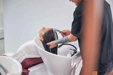 Customer enjoying the haircare in the hair salonの写真素材