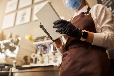 Convenient modern device in hands of the waitressの写真素材