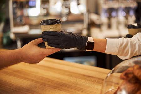 Waitress in rubber gloves giving the order to her visitorの写真素材