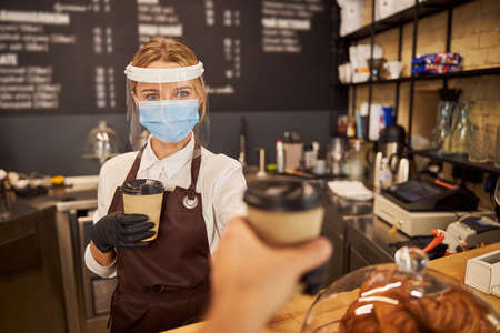 Confident protected barista working during the quarantineの写真素材