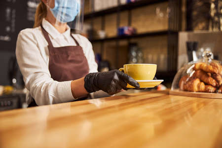 Wooden surface of the bar counter and barista working at itの写真素材