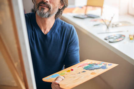 Dedicated artist making a new painting in his workshopの写真素材