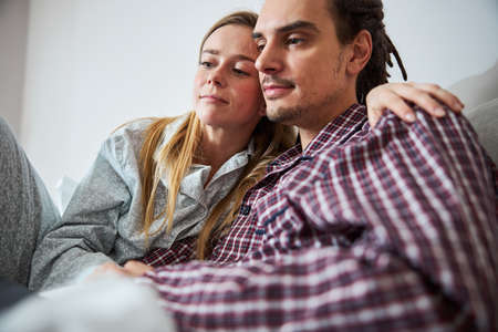 Beautiful young couple cuddling in bed at home